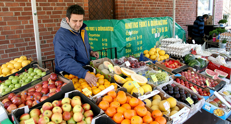 En småföretagare inom fruktbranschen har ett marknadsstånd fullt med olika frukter.