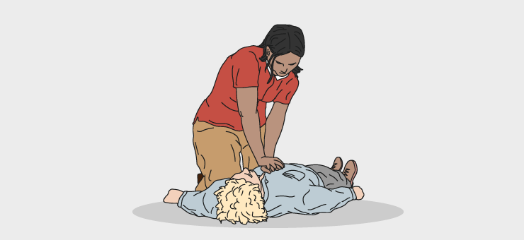Una persona practicando una reanimación cardiopulmonar a otra tendida en el suelo.