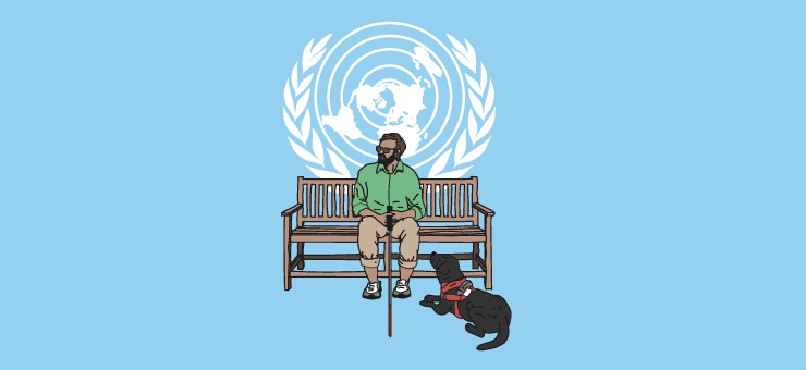 A man with impaired eyesight seated on bench with a guide dog next to him and the flag of the United Nations in the background. 